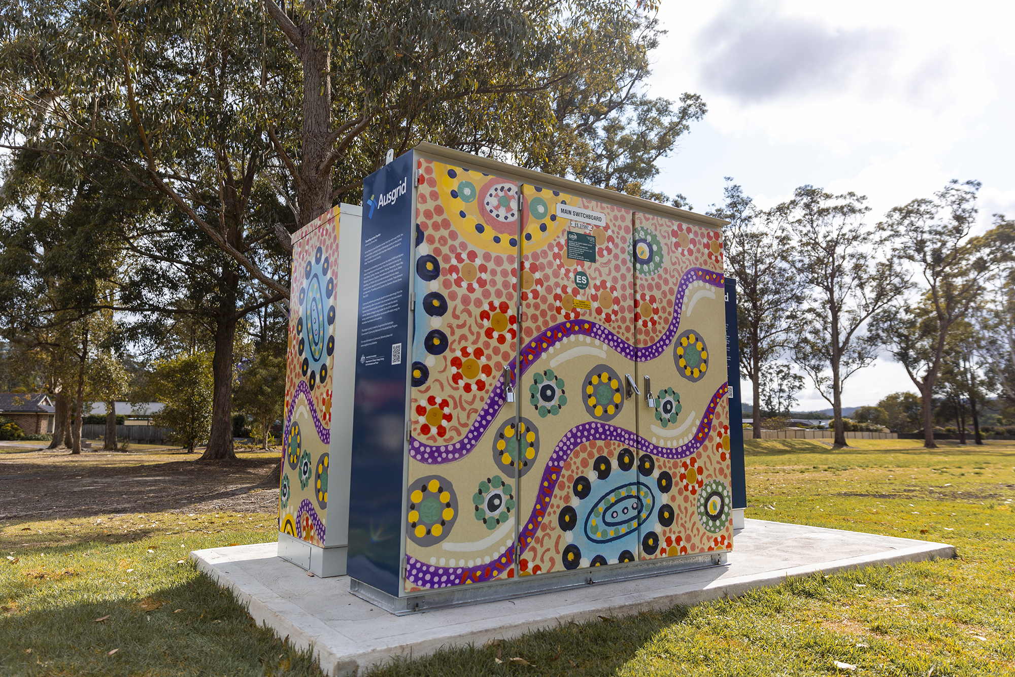 Ausgrid community battery decorated with bright, indigenous artwork.