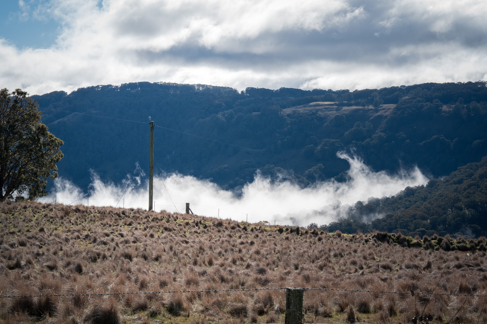 Landscape with hills and clouds appearing above the ridge in the Hunter region.