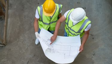 Two construction workers checking plans