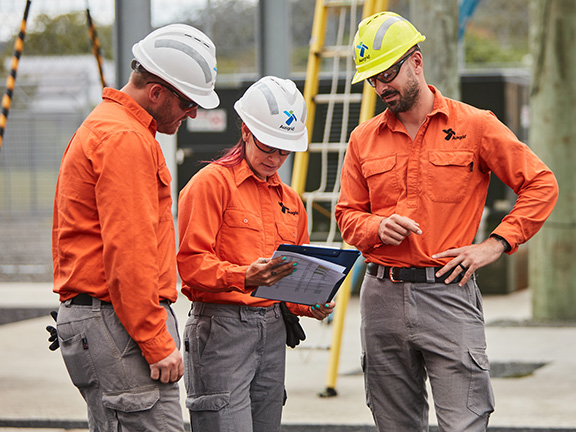 Three field employees check their safety checklist before commencing work