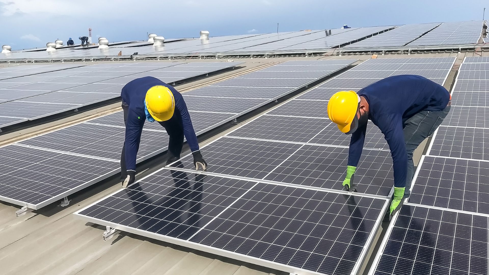 Two workers installing solar panel