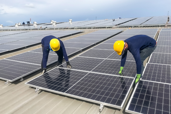 Two workers repairing solar panel